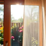 Zainstalowane moskitiery na wymiar na oknie, pokazujące trwałą siatkę ochronną.